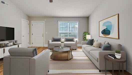 A living room with a grey couch, a coffee table, and a ceiling fan.