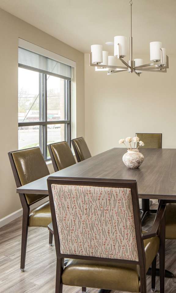 A dining room with a table and chairs.