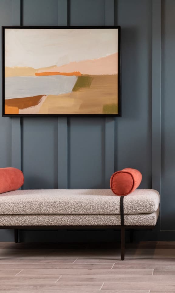 a living room with a chair and a lamp and a painting on the wall