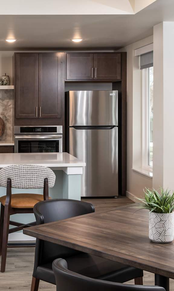 A kitchen with a bar area and a dining table.