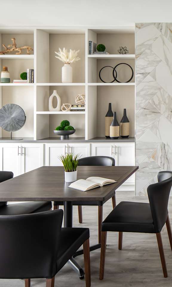 A modern dining room with a table set for four.