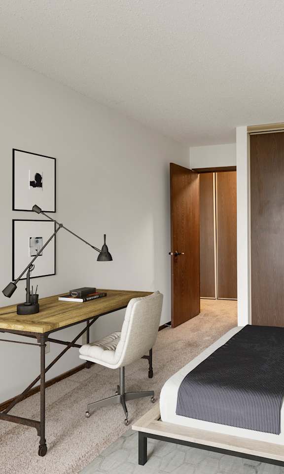 A bedroom with a bed, desk, and chair.