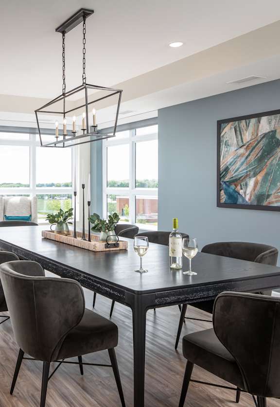 a dining room with a table and chairs and a large window