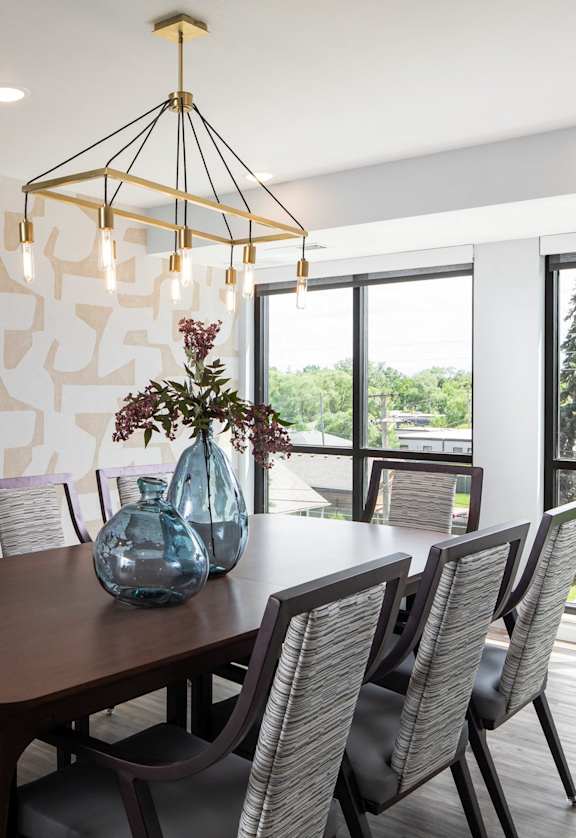 a dining room with a wooden table and chairs and a large window