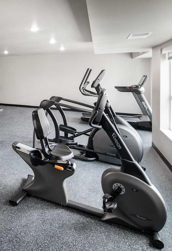 A spacious gym with a variety of equipment including treadmills, elliptical machines, and weights.