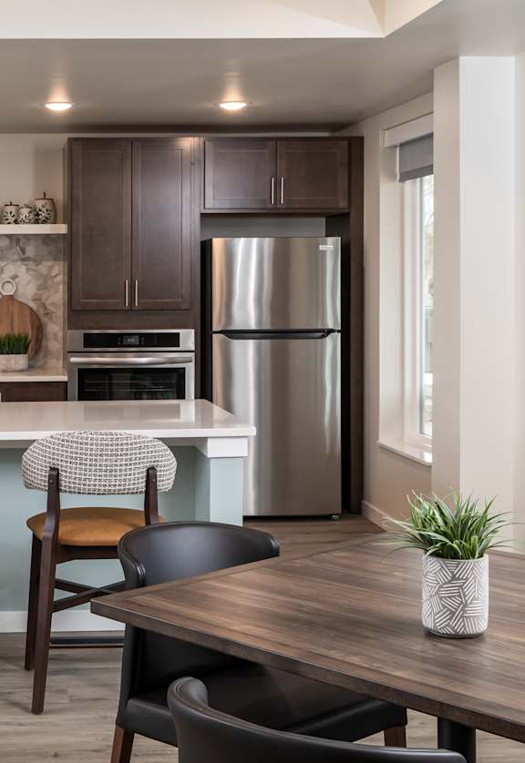 A kitchen with a bar area and a dining table.