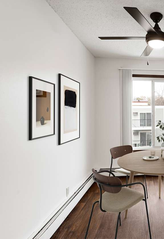 A dining room with a round table and chairs.