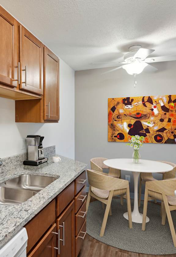 A kitchen with a marble countertop and wooden cabinets. at Minnehaha Manor, Oakdale, Minnesota