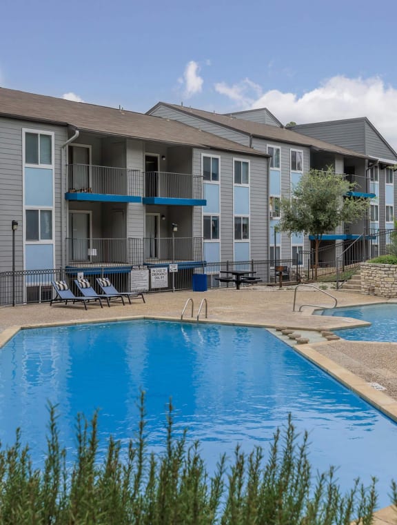 A pool surrounded by chairs and apartment buildings.at The Keller, Texas