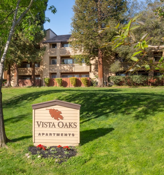 a view of the vista oaks apartments sign in front of the building