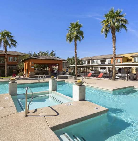 A BBQ grill is in the foreground of a residential area with palm trees.