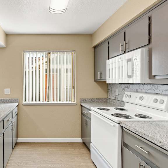 A kitchen with a stove, sink, and cabinets.at Redwood Cove Apartments, California, 95928