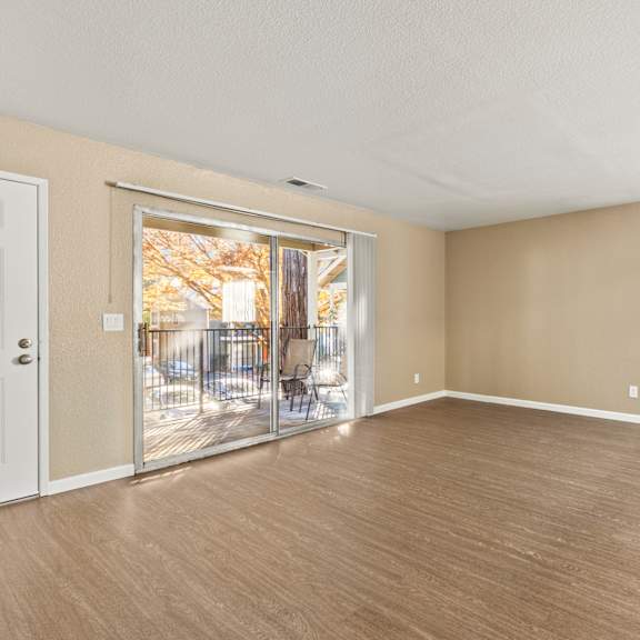 A room with a sliding glass door leading to a backyard.at Redwood Cove Apartments, California