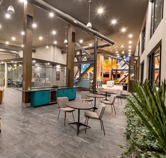 the lobby of a building with tables and chairs