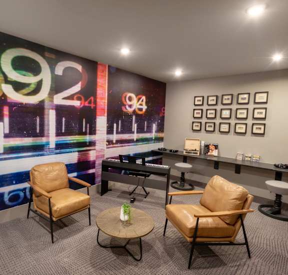 a lounge area with chairs and a piano and graffiti on the wall