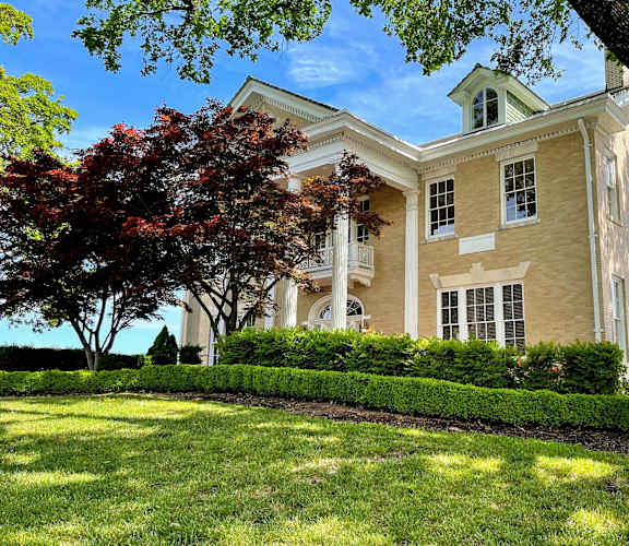 A large, well-maintained building with a green lawn in front.