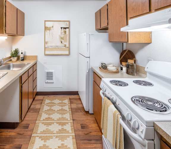 a kitchen with wooden cabinets and a white stove top oven