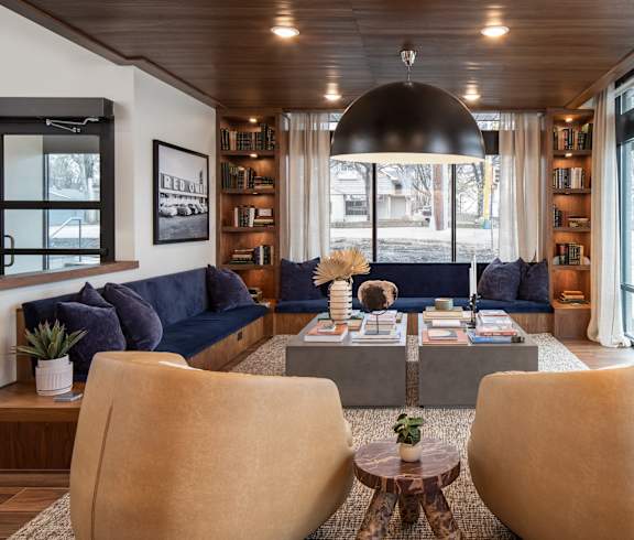 a living room with a blue couch and a table with chairs