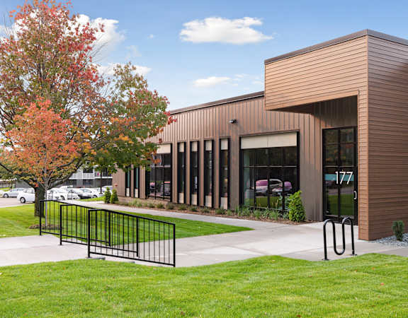 a building with large windows and a grassy area in front of it at Villages on McKnight, St. Paul, Minnesota