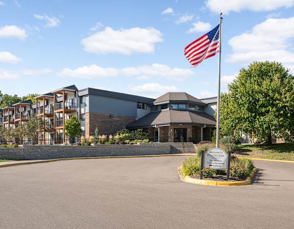A building with a sign in front of it and an American flag on a flagpole.