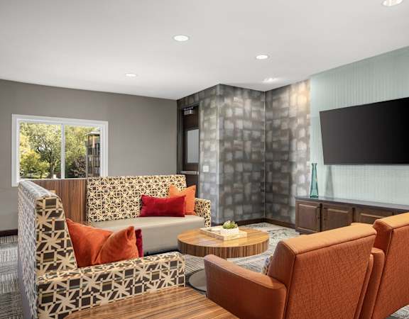 A modern living room with a stone wall and a flat screen TV.