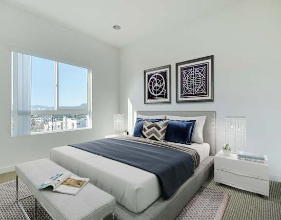 A bedroom with a large bed and two picture frames on the wall.
