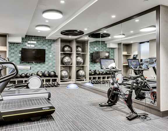 A well-equipped gym with treadmills, exercise bikes, and weights.