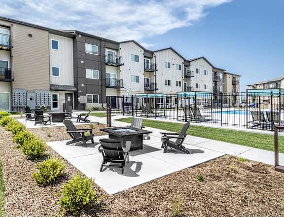 A sunny day at a residential complex with a pool and a patio area.