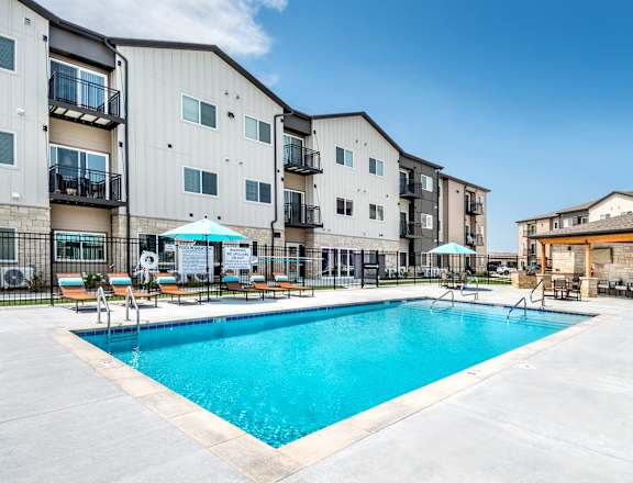 A swimming pool in front of apartment buildings.