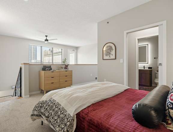 A bedroom with a bed, dresser, and window.