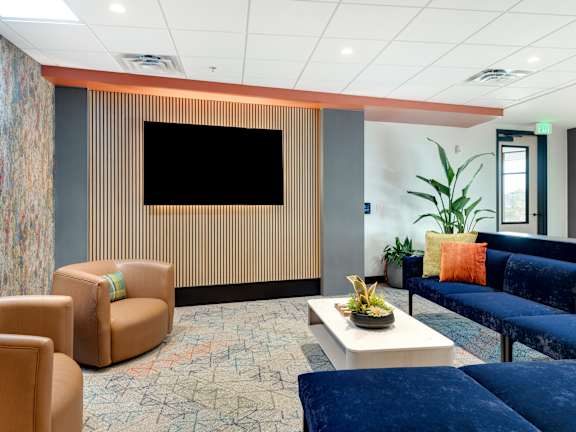 a living room with a couch and a coffee table and large windows  at Zelia on Seven, St Louis Park