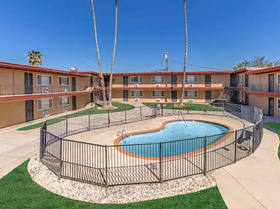 a building with a pool and a fence in front of it