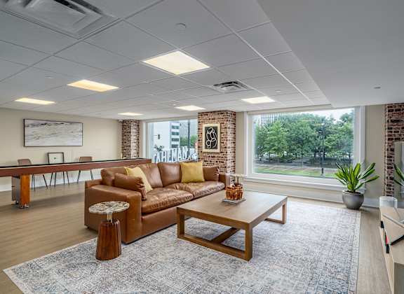 A living room with a brown couch, a wooden coffee table, and a flat screen TV.