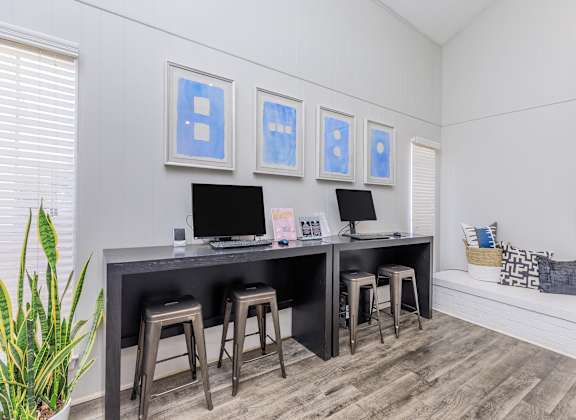 a office with a desk and three stools