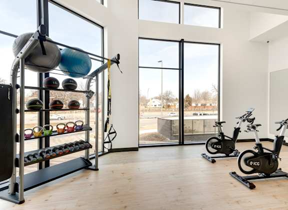 A gym with a row of exercise bikes and a rack of kettlebells. at Zelia on Seven, Minnesota, 55416