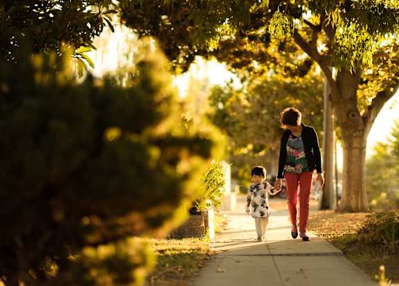 a mother and child walking down a sidewalk