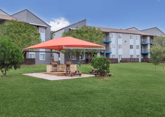 A large grassy area with a picnic table and a red canopy.at The Keller, Texas