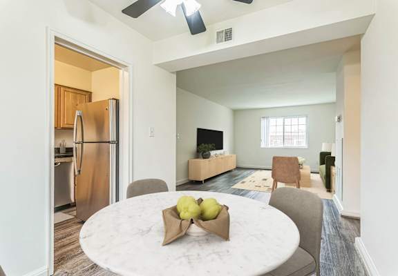 A kitchen with a refrigerator and a dining table with chairs at The Fields of Silver Spring, Maryland
