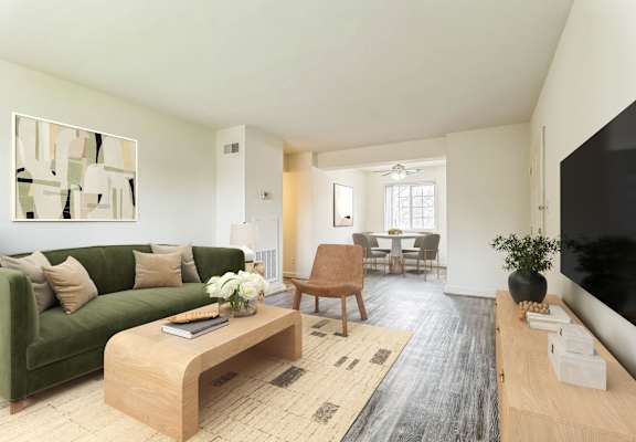 A living room with a green couch and a wooden coffee table at The Fields of Silver Spring, Maryland