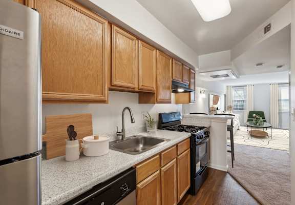 A kitchen with wooden cabinets and a stainless steel refrigerator at The Fields of Bethesda, Chevy Chase, 20815