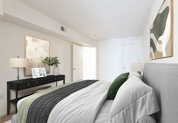 A bedroom with a bed, nightstand, and a painting on the wall at The Fields of Bethesda, Chevy Chase, 20815