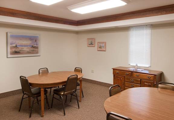 A conference room with a wooden table and chairs.