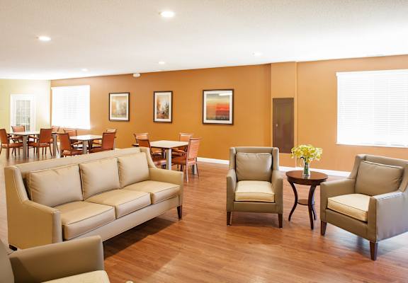 A living room with a couch, chairs, and a table with flowers on it.