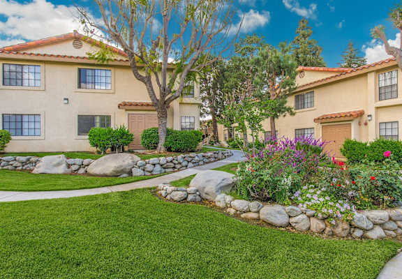 the front yard of a house with rocks and grass at Victoria Springs Apartments, Riverside