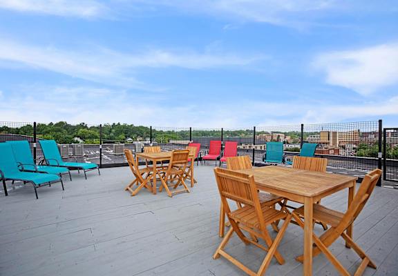 A wooden table and chairs are set up on a wooden deck.