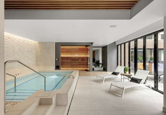 a swimming pool in the middle of a lobby with two chairs