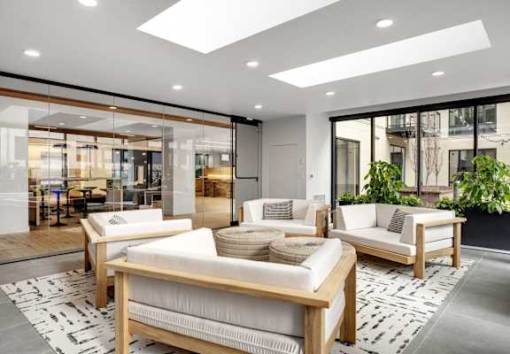 A modern living room with a glass wall and a white sofa.