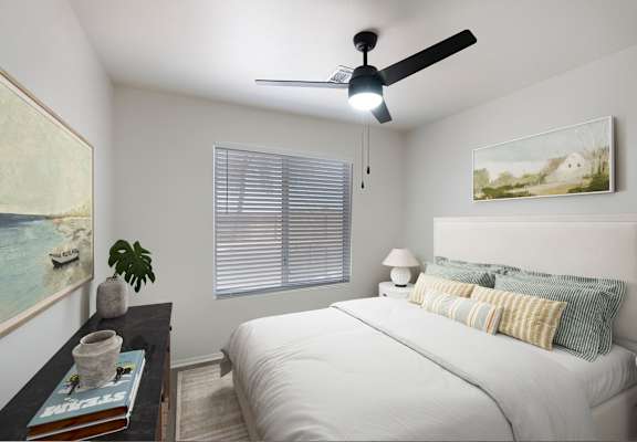 A bedroom with a bed, a ceiling fan, and a painting on the wall.
