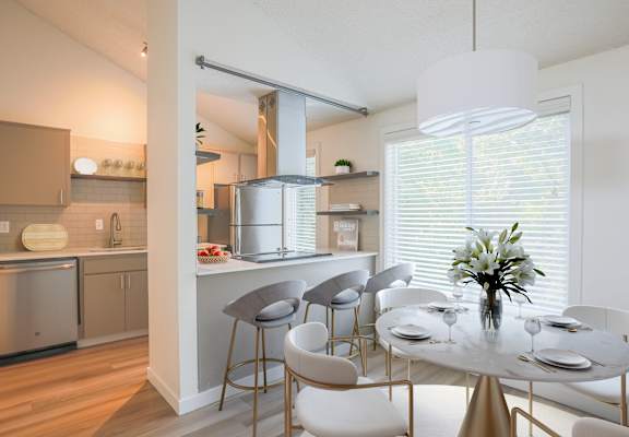 A modern kitchen with a dining table set for four.