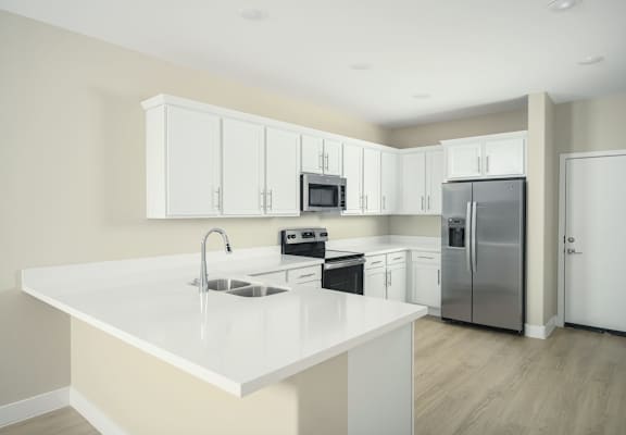 A kitchen with white cabinets and appliances.